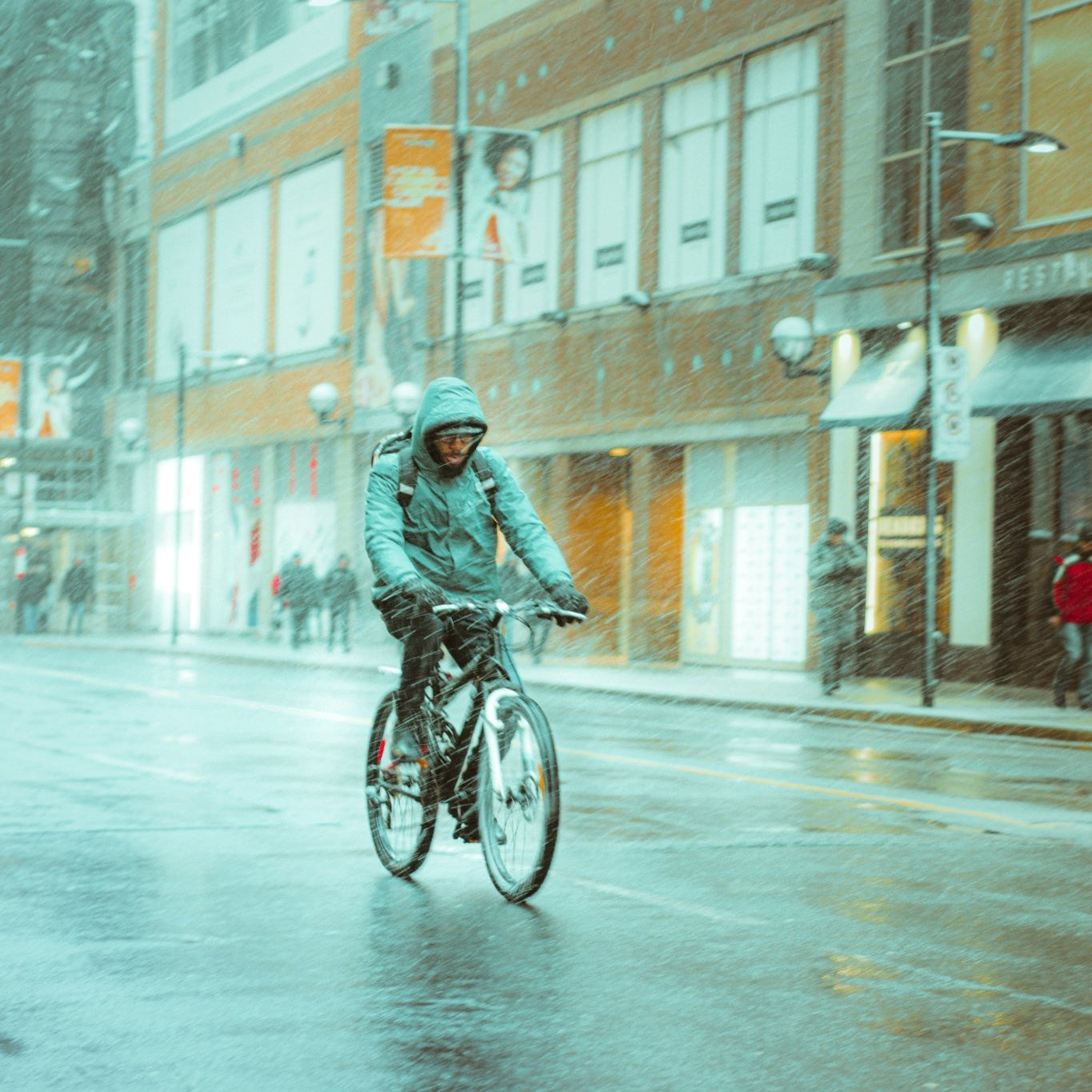 a man riding a bike in the rain